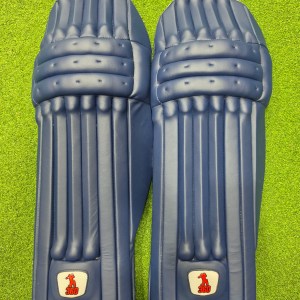 Top face view of EM 360 Bold adult navy blue cricket batting pads on green artificial turf on Alberta.