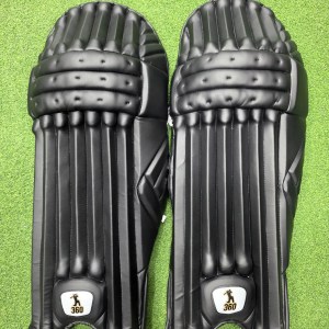 Top view of EM 360 No 17 adult black cricket batting pads on green artificial turf on Alberta.